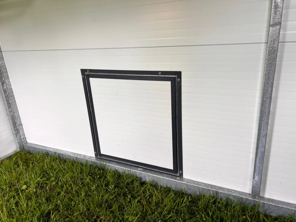 Wejście dla kur w dużym mobilnym kurniku