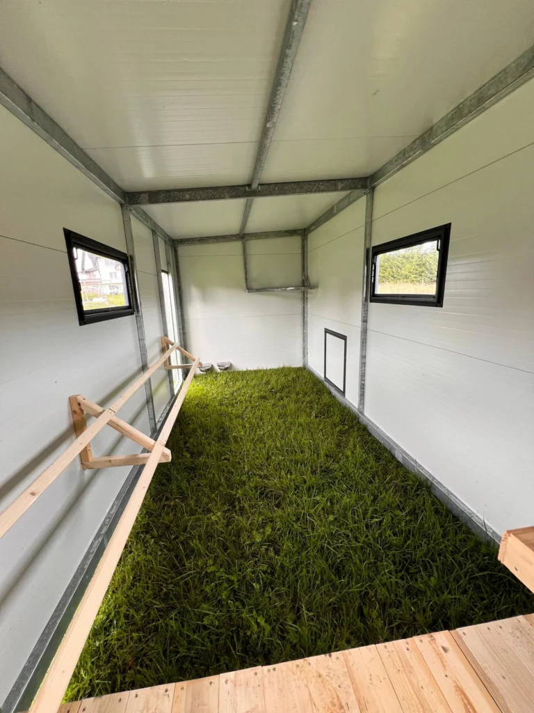 Duży mobilny kurnik w środku i świeża zielona trawa