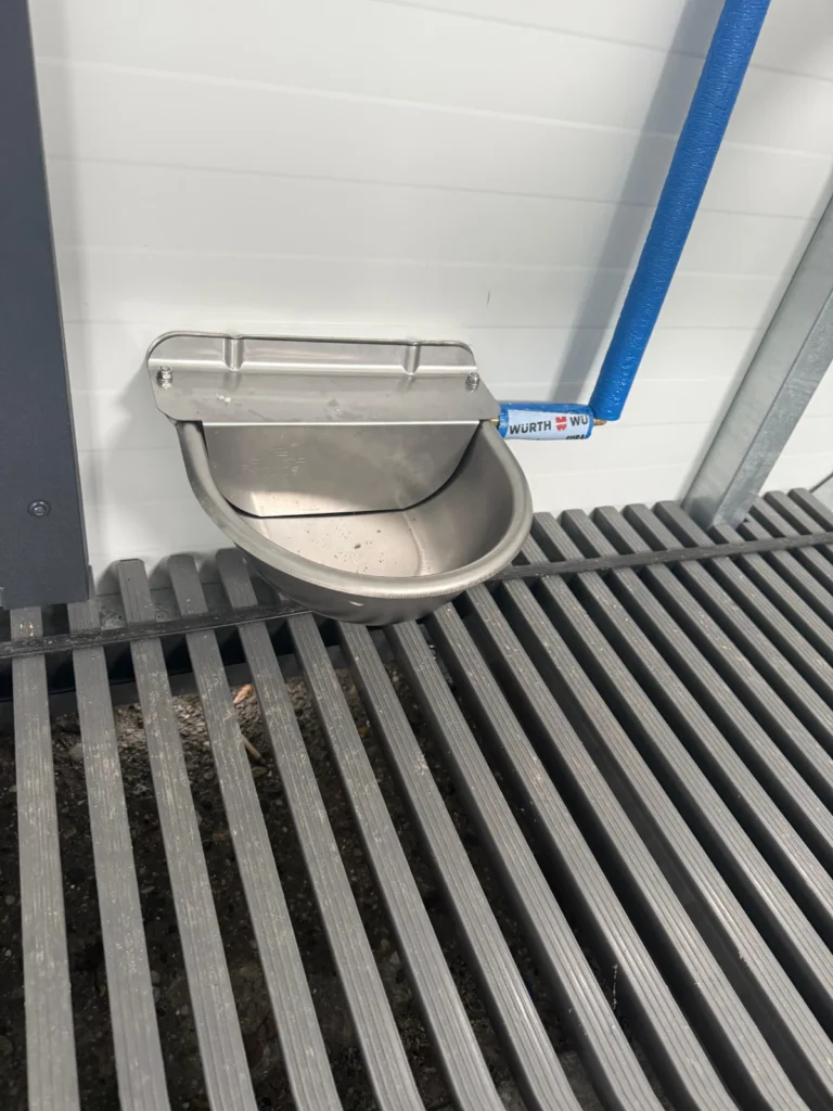 Metalowe poidło z automatycznym zasilaniem ze zbiornika w mobilnym kurniku XXL od Tiny House Design