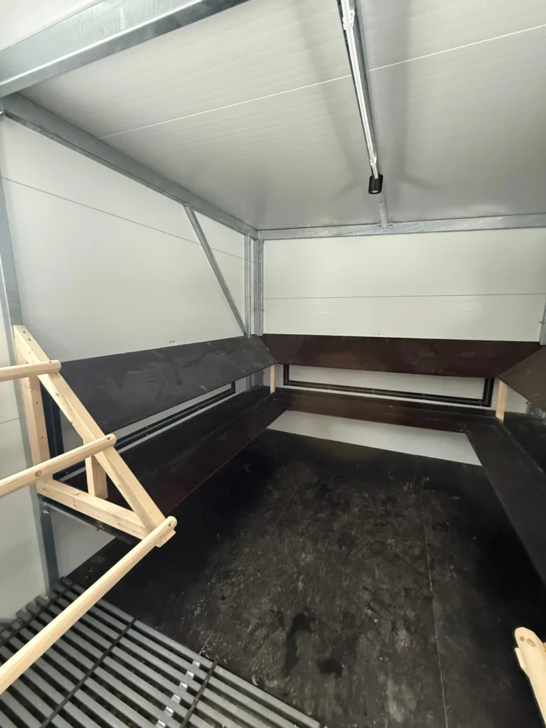 Podesty z miejscem na gniazda i klapy serwisowe otwierane z zewnątrz do łatwiejszego wyjmowania jaj w mobilnym kurniku XXL od Tiny House Design